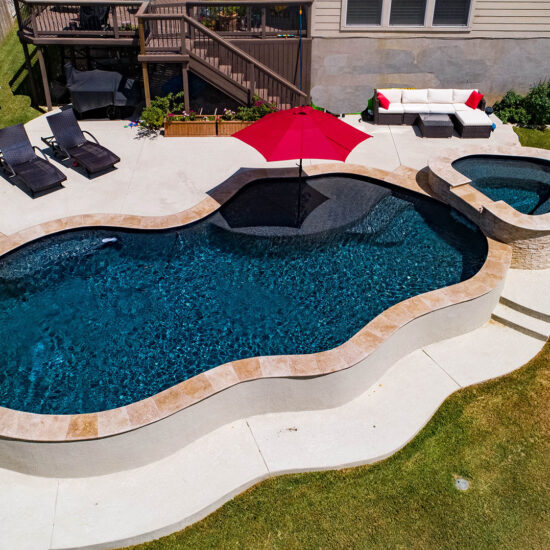 Modern contemporary pool with a red umbrella creates a relaxing backyard escape.