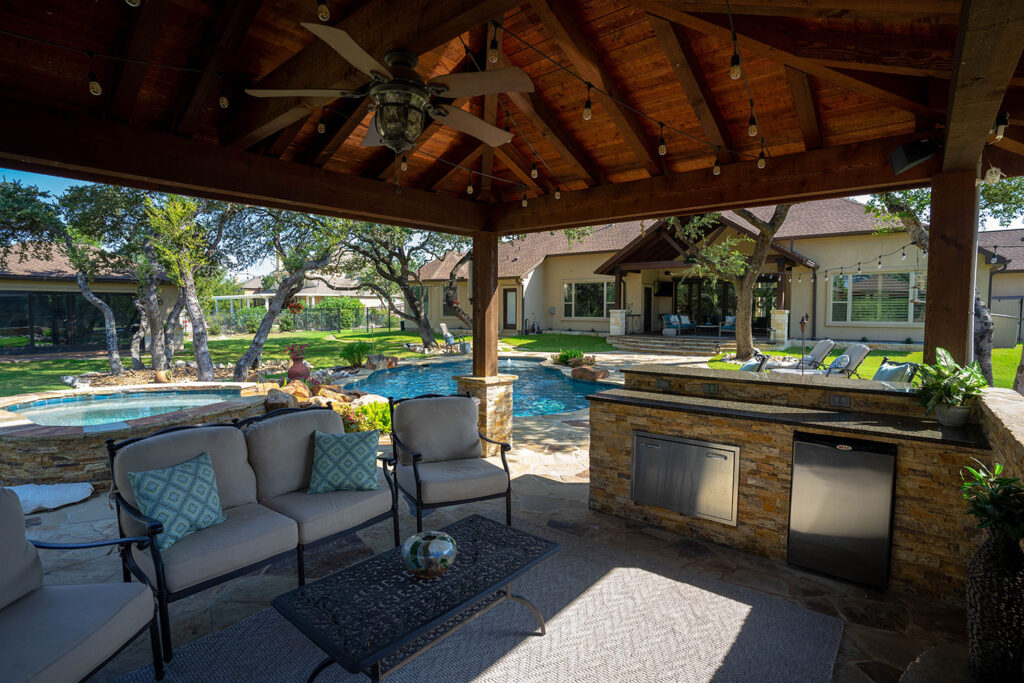 This custom poolscape features a relaxing backyard kitchen and outdoor living space.